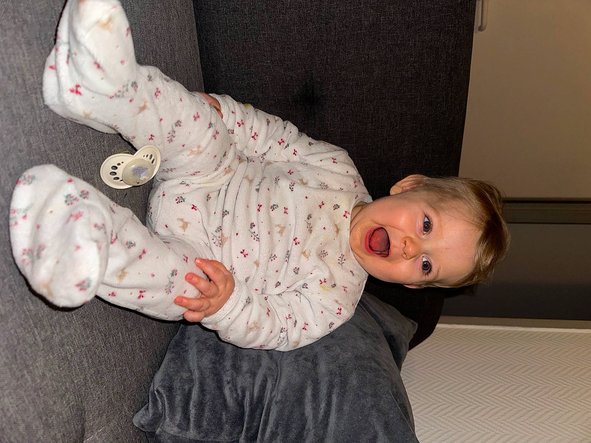 Kayden a rejoint le concours — aidez-le/la à gagner de superbes lots ! baby, baby_products, baby_toddler_clothing, carmine, child, comfort, facial_expression, flooring, foot, human_body, human_leg, joint, leg, pattern, person, sitting, skin, sleeve, smile, sock