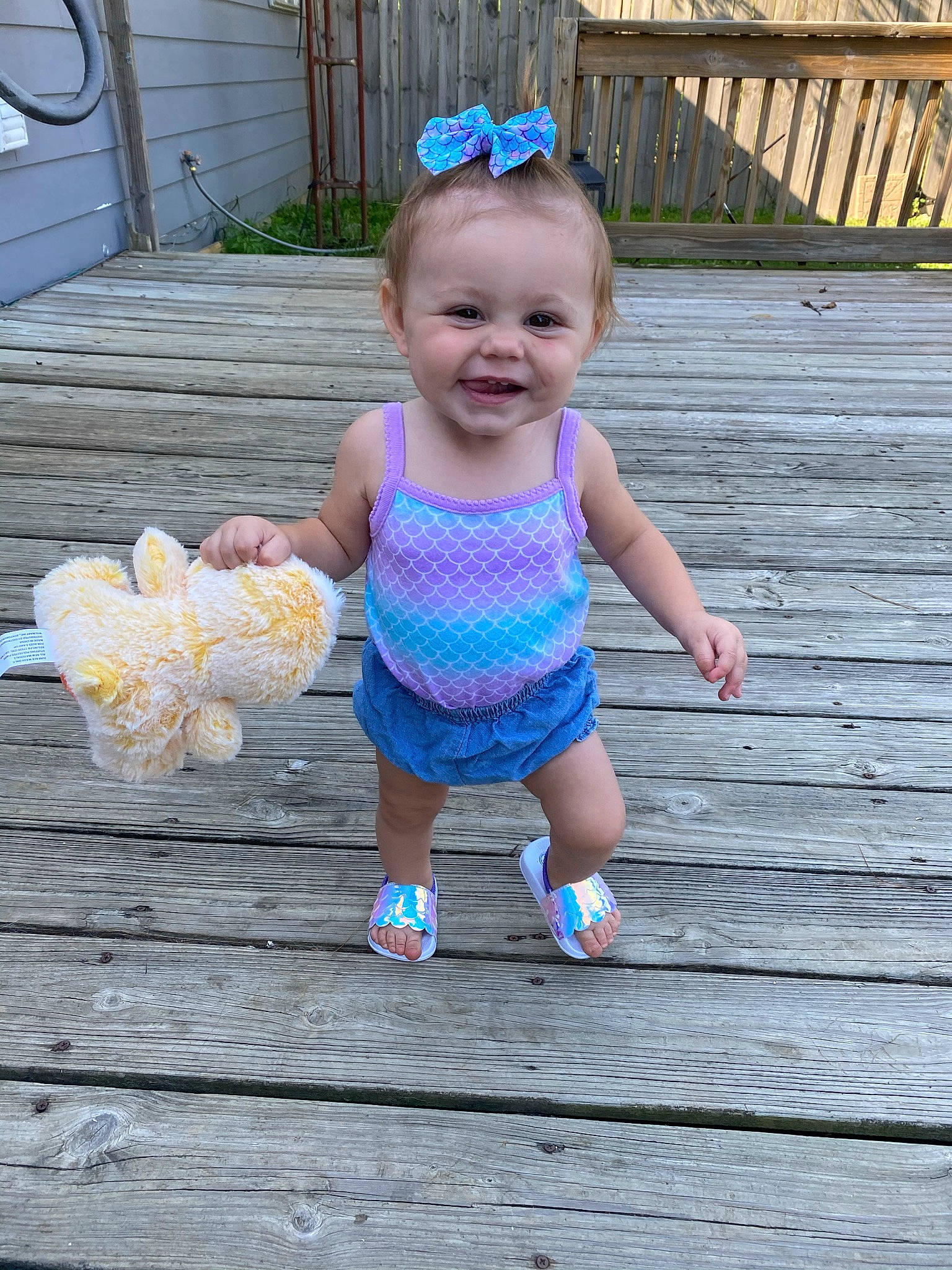 Laylah is registered to the contest to win money with this photo: baby, baby_products, baby_toddler_clothing, backyard, child, day_dress, hair_accessory, headband, headpiece, joy, pattern, person, pink, plank, sandal, toddler, wood, yard