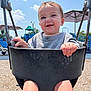 baby, child, swing, playground, outdoor, smile, happy, sky, sunny, clothing, seat, hand, legs, play, fun, daytime, person, park, umbrella, equipment