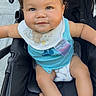 Giovanni joined the competition — help win amazing prizes! baby, child, infant, stroller, portrait, sitting, face, eyes, curly_hair, smiling, serious_expression, bib, turquoise_clothing, diaper, pacifier_clip, outdoor, photography, closeup, baby_gear, cute