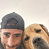 animal, beard, bond, cap, casual, closeup, companionship, dog, expression, face, friendship, headwear, human, man, outdoor, overcast, pet, portrait, selfie, smile