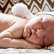 Waylon is registered to the contest to win money with this photo: newborn, baby, sleeping, hat, knitted_hat, pom_pom, blanket, patterned_blanket, soft_skin, peaceful, close_up, infant, resting, cute, portraits, indoor, cozy, toddler, child, face