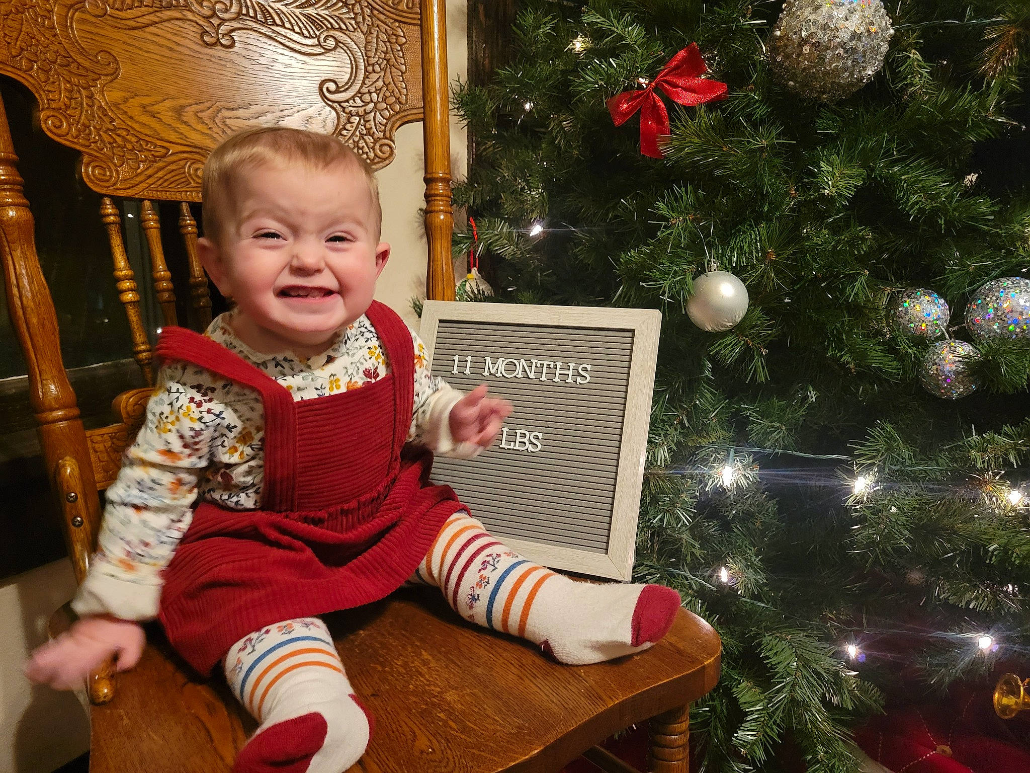 Rylee joined the competition — help win amazing prizes! baby, baby_toddler_clothing, chair, christmas, christmas_decoration, christmas_eve, christmas_ornament, christmas_tree, conifer, event, evergreen, happy, holiday, holiday_ornament, human_body, joy, ornament, person, room, smile