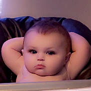 Isabella is registered to the contest to win money with this photo: baby, child, face, arms, cushion, indoor, expression, portrait, skin, head, relaxing, serious, young, infant, person, cute, chubby, sitting, light, background