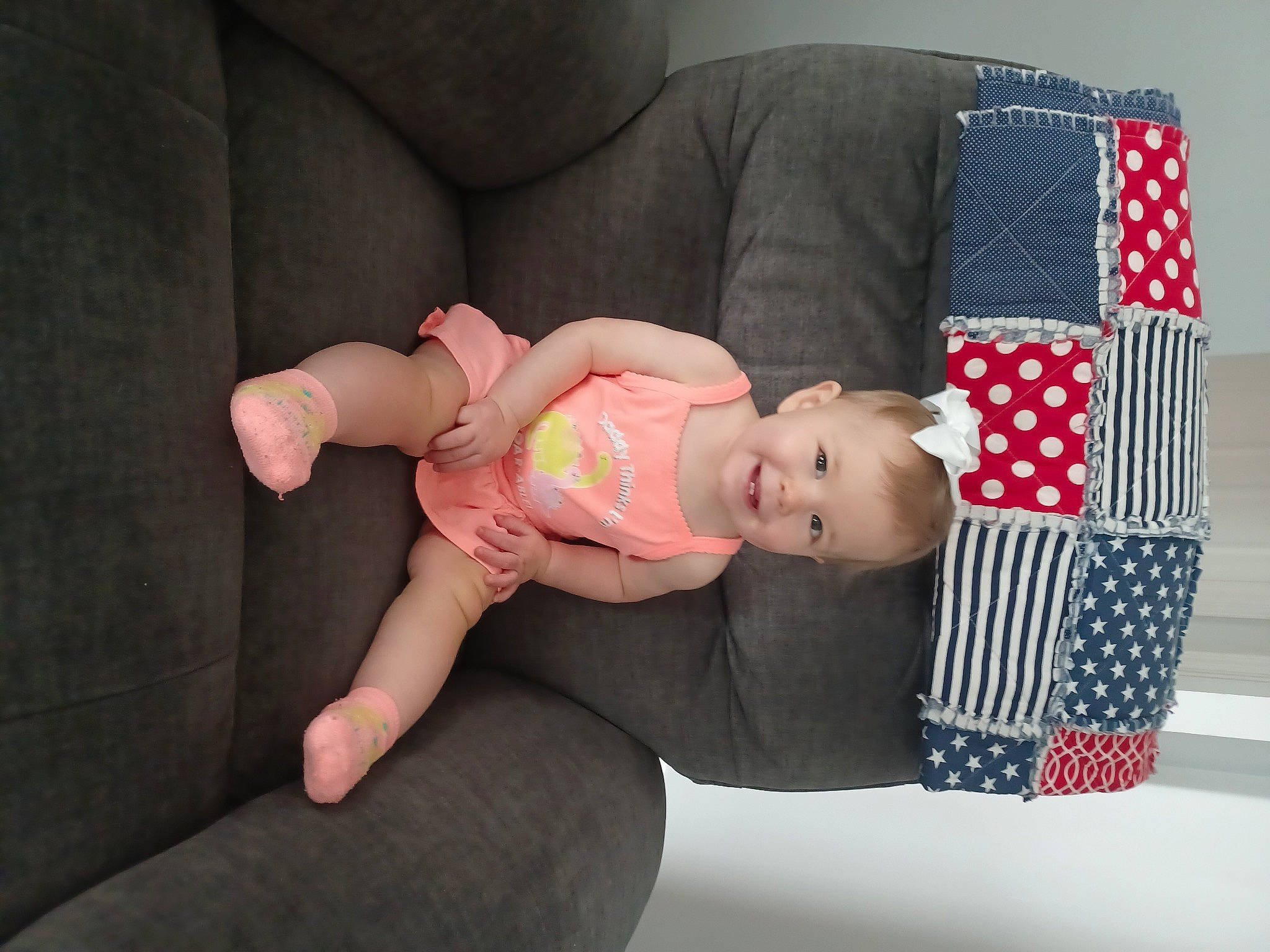 Mckenna is registered to the contest to win money with this photo: baby, baby_products, baby_toddler_clothing, child, comfort, couch, foot, hat, human_leg, joy, knee, lap, linens, pattern, person, plaid, product, sitting, sleeve, tartan