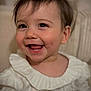 baby, child, infant, portrait, close_up, smiling, teeth, tongue, eyes, eyelashes, hair, ear, white_clothing, ruffled_collar, rosy_cheeks, skin, happy, indoor, soft_lighting, candid