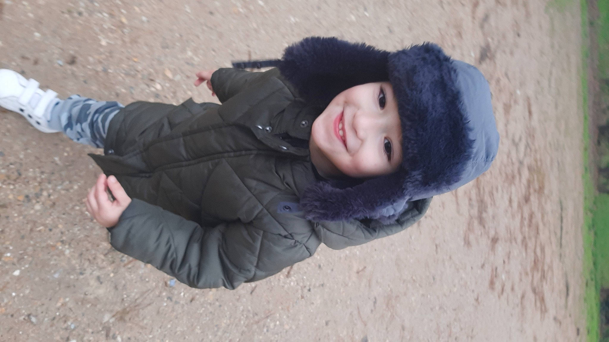 Dylan participe au concours pour gagner de l'argent avec cette photo : beach, child, comfort, denim, freezing, fun, fur, glove, grass, happy, headwear, jacket, joy, landscape, leisure, person, sand, sitting, smile, toddler
