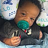 Blaze is registered to the contest to win money with this photo: baby, pacifier, car_seat, blanket, neck_pillow, dinosaur_pattern, child, infant, cute, black_hair, clothing, seatbelt, indoor, portrait, comfort, resting, young_child, soft_texture, closeup, baby_boy