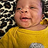 Blaze is registered to the contest to win money with this photo: baby, infant, yellow_sweater, smile, face, leopard_print, blanket, child, portrait, happy, cute, closeup, person, skin, head, eyes, mouth, indoors, apparel, newborn