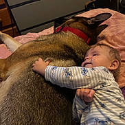 Noah joined the competition — help win amazing prizes! baby, dog, cuddle, pajamas, blanket, pet, friendship, comfort, indoor, bedroom, child, animal, sleeping, relaxation, soft, fur, hand, face, rest, cute