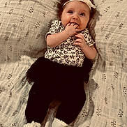 Edith joined the competition — help win amazing prizes! baby, infant, child, face, headband, clothing, socks, blanket, pattern, tutu, hands, smiling, cute, lying_down, portrait, young_child, indoor, soft_lighting, expression, adorable