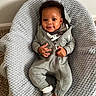 baby, infant, child, smiling, grey_onesie, hood, blanket, texture, cozy, indoor, carpet, happy, cute, socks, portrait, sitting, young_child, clothing, person, baby_boy