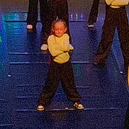 Joy a rejoint le concours — aidez-le/la à gagner de superbes lots ! child, children, dance, dancer, performance, stage, costume, yellow_top, black_pants, crossed_arms, group, indoor, lighting, colorful_lights, footwear, young, posing, expression, floor, event