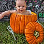 Maddox is registered to the contest to win money with this photo: baby, pumpkin, halloween, grass, tombstone, skeleton_hand, skull_pattern, flowers, decorations, baby_in_pumpkin, outdoor, holiday, festive, cute, child, orange, green, background, portrait, smiling