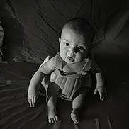 Ronnie is registered to the contest to win money with this photo: baby, infant, black_and_white, portrait, sitting, expression, face, eyes, arms, legs, skin, light, shadow, texture, clothing, indoor, cute, child, person, young