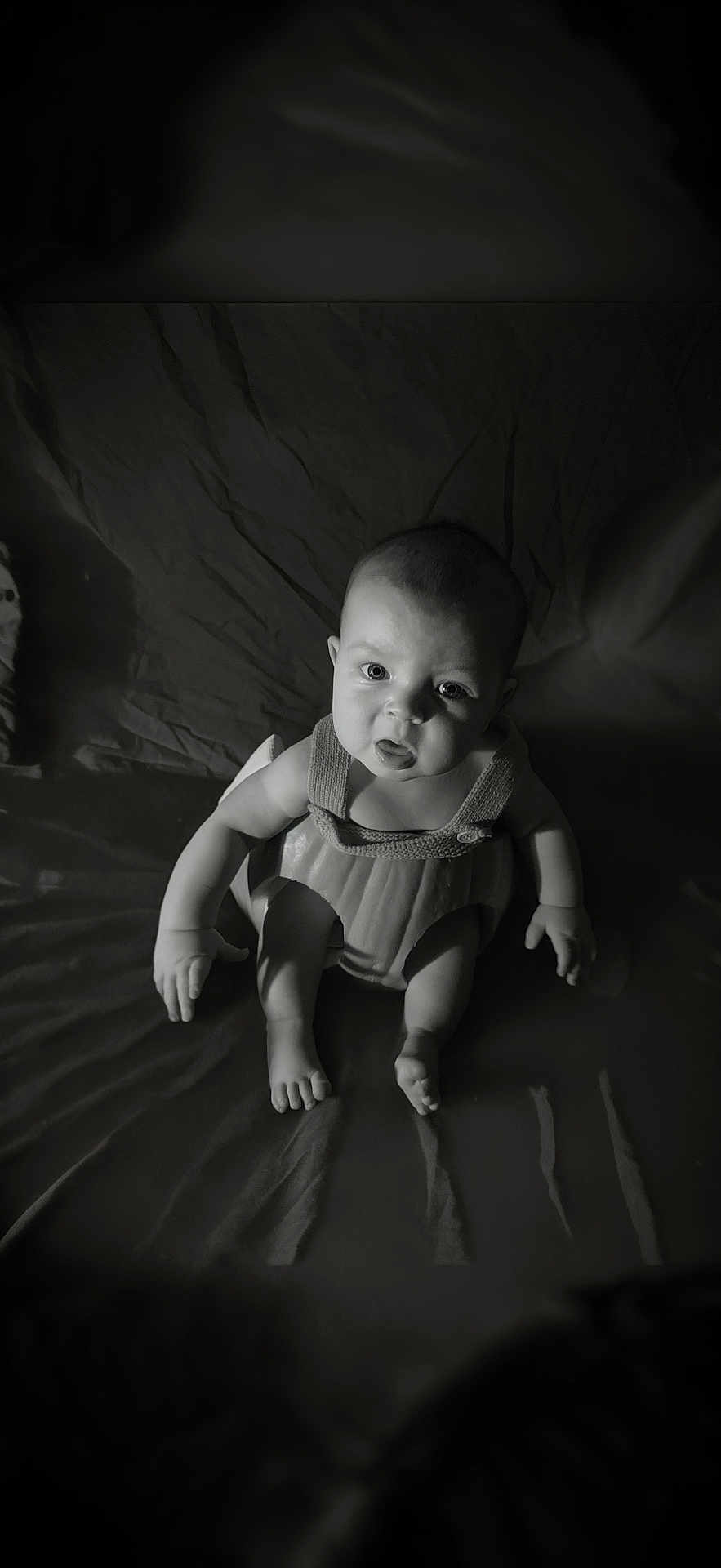 Ronnie is registered to the contest to win money with this photo: baby, infant, black_and_white, portrait, sitting, expression, face, eyes, arms, legs, skin, light, shadow, texture, clothing, indoor, cute, child, person, young