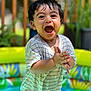 toddler, child, smiling, happy, wet_hair, striped_shirt, clapping_hands, inflatable_pool, colorful, outdoor, garden, greenery, summer, water, playful, cute, portrait, daylight, fun, joy
