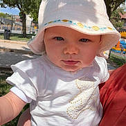 Rose a rejoint le concours — aidez-le/la à gagner de superbes lots ! baby, blue_eyes, casual_clothing, child, cute, daylight, hat, holding, infant, leafy_tree, nature, outdoor, park, person, portrait, skin, summer, sunlight, tree, white_clothing