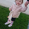 blanket, candid, casual, child, cute, daylight, footwear, grass, happy, holding_hand, outdoor, person, pink_jacket, playing, smiling, snack, toddler, toy, winter_clothing, young_child