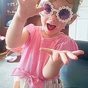Ruby joined the competition — help win amazing prizes! child, girl, sunglasses, pink_top, colorful_skirt, pigtails, playful, smiling, indoor, toys, bookshelf, carpet, furniture, happy, cute, person, portrait, fun, expressive, decor