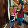 Benjamin is registered to the contest to win money with this photo: child, toy, statue, wooden, moose, cap, red_shirt, blue_pants, carpet, indoor, door, curious, hugging, footwear, socks, playful, large_object, decor, person, smiling
