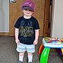 Benjamin joined the competition — help win amazing prizes! toddler, child, smiling, indoor, carpet, door, bucket_hat, baseball_cap, tshirt, shorts, sneakers, toy_table, colorful, playful, standing, floor, person, clothing, happy, footwear