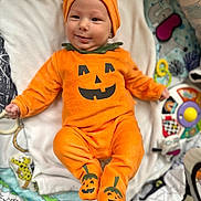 Sohan a rejoint le concours — aidez-le/la à gagner de superbes lots ! baby, infant, smiling, pumpkin_costume, orange_clothing, hat, booties, blanket, toy, playmat, child, cute, happy, indoor, portrait, infant_clothing, holiday, halloween, costume, face