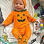 baby, infant, smiling, pumpkin_costume, orange_clothing, hat, booties, blanket, toy, playmat, child, cute, happy, indoor, portrait, infant_clothing, holiday, halloween, costume, face