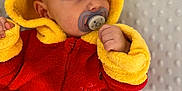 Sohan a rejoint le concours — aidez-le/la à gagner de superbes lots ! baby, pacifier, hoodie, winnie_the_pooh, red_clothing, yellow_clothing, infant, cute, soft_texture, blanket, child, face, ears, sleepwear, resting, indoors, young_child, portrait, warm_clothing, comfort