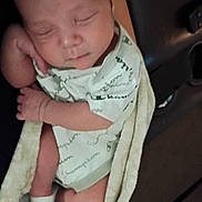 Legacy is registered to the contest to win money with this photo: arm, baby, blanket, carrier, child, closeup, clothing, cozy, face, hand, indoors, infant, newborn, onesie, portrait, resting, seated, sleeping, sock, vehicle