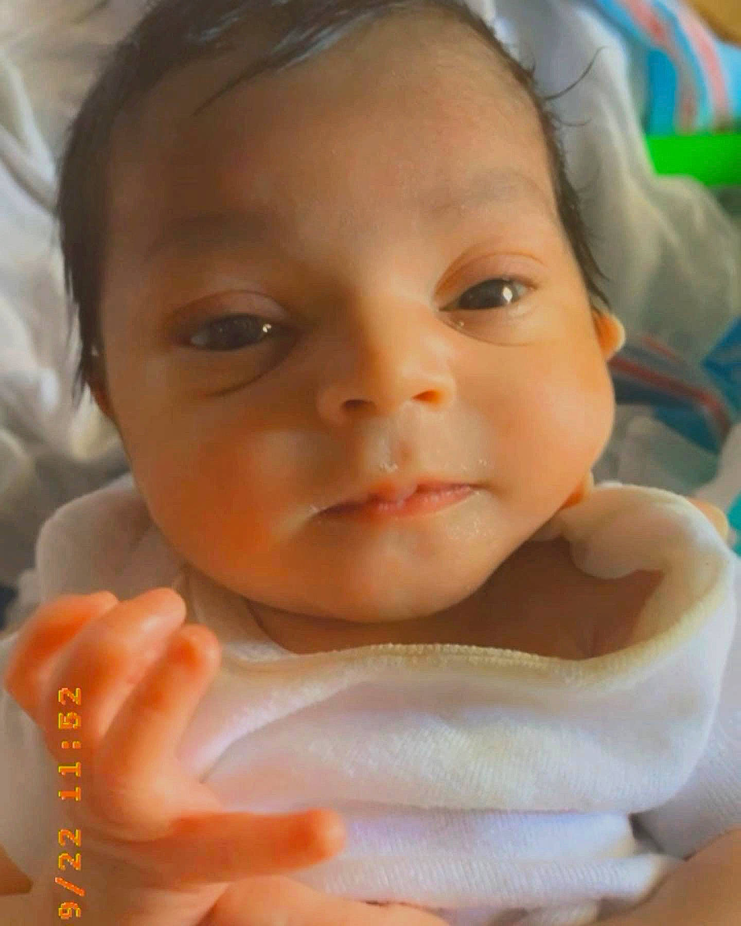 Gabriella is registered to the contest to win money with this photo: baby, baby_toddler_clothing, cheek, child, chin, eye, eyebrow, eyelash, finger, gesture, happy, head, iris, lip, mouth, neck, nose, person, skin, thumb