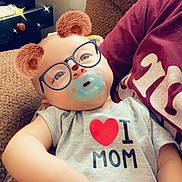 Kinslee joined the competition — help win amazing prizes! baby, onesie, pacifier, glasses_filter, bear_ears_filter, couch, brown_couch, arm, hand, infant, child, indoor, person, cute, filter_effect, smile, relaxing, love_mom, casual_clothing, portrait