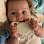 baby, infant, face, hands, teething_toy, blanket, clothing, cute, closeup, skin, expression, child, soft_toy, indoor, portrait, happy, smile, lying_down, fingers, play