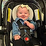 baby, baby_boots, bow, car_seat, child, clothing, cute, denim_jacket, footwear, happy, headband, indoor, infant, person, portrait, safety, seatbelt, small_child, smiling, toddler