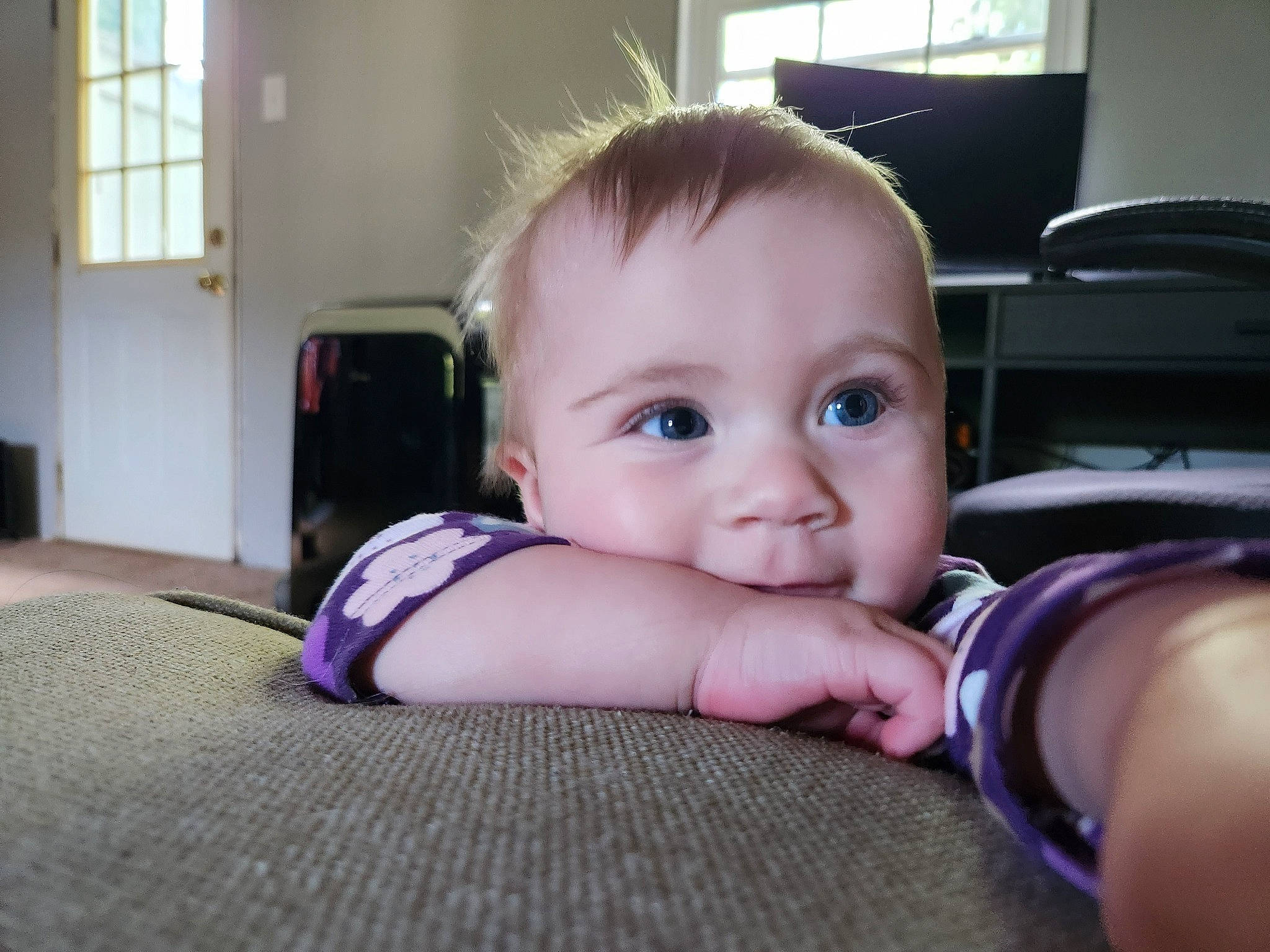 Ela is registered to the contest to win money with this photo: baby, baby_toddler_clothing, cheek, child, comfort, door, finger, flooring, fun, hairstyle, hand, happy, leg, person, room, sitting, skin, smile, thumb, toddler