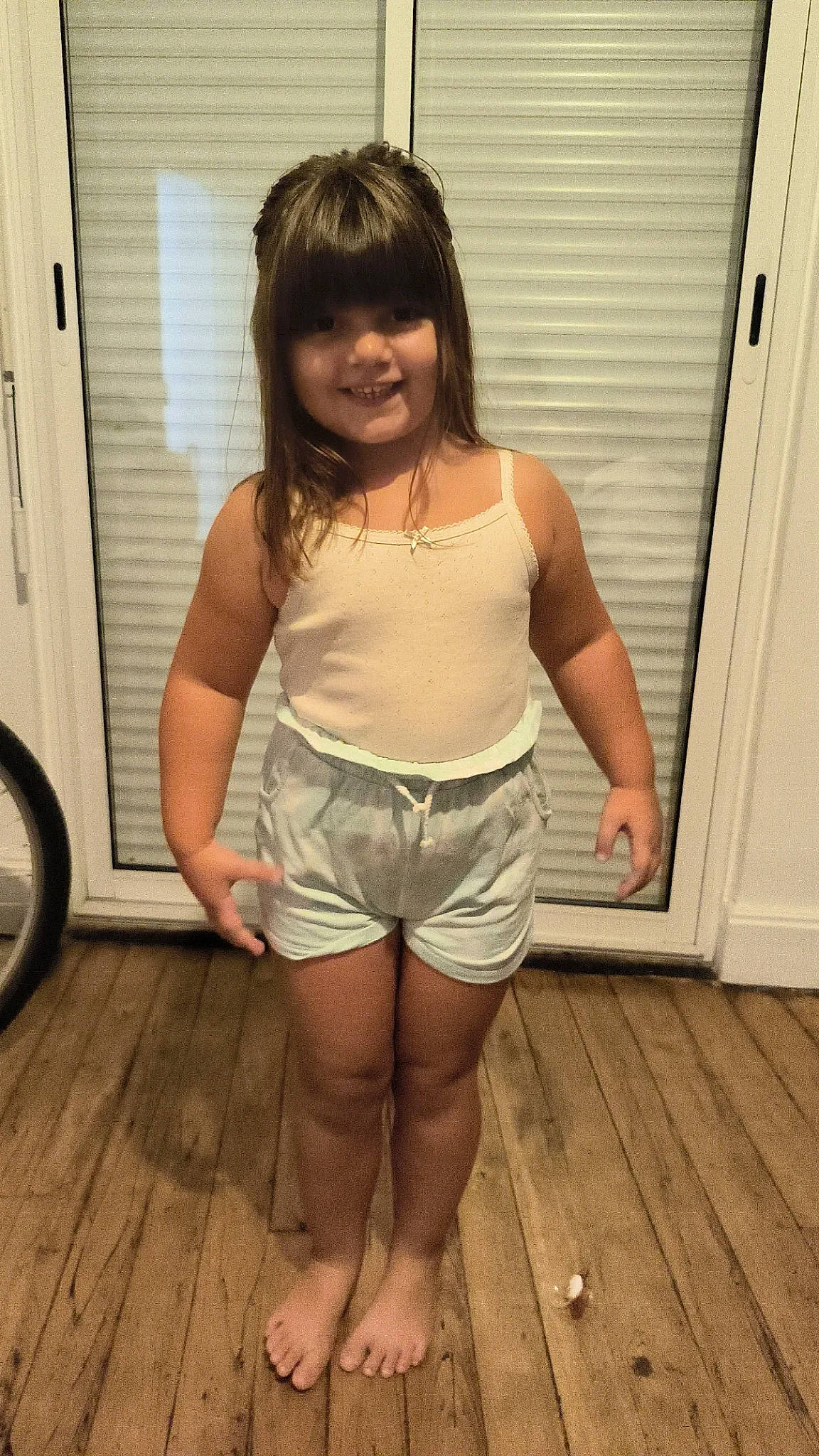 Victoire participe au concours pour gagner de l'argent avec cette photo : abdomen, brown_hair, chest, flooring, hardwood, human_leg, jean_short, joy, knee, leg, long_hair, person, shorts, sleeve, sleeveless_shirt, smile, thigh, tire, trunk, waist