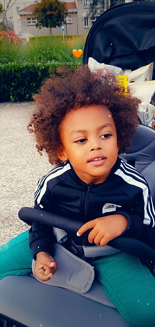Tidiane participe au concours pour gagner de l'argent avec cette photo : afro, baby_toddler_clothing, black_hair, child, comfort, cool, electric_blue, flash_photography, fun, grass, happy, jheri_curl, leisure, person, recreation, sitting, skin, smile, toddler, vacation