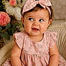 baby, child, girl, portrait, blue_eyes, pink_bow, pink_dress, smiling, curious, sitting, indoor, flower_background, cute, chubby_cheeks, headband, infant, happy, childhood, fashion, cozy