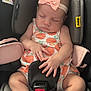 Star is registered to the contest to win money with this photo: baby, sleeping, car_seat, headband, bow, dress, peach_pattern, infant, child, safety, seat_belt, pink, skin, hands, feet, closeup, cute, peaceful, indoors, padding
