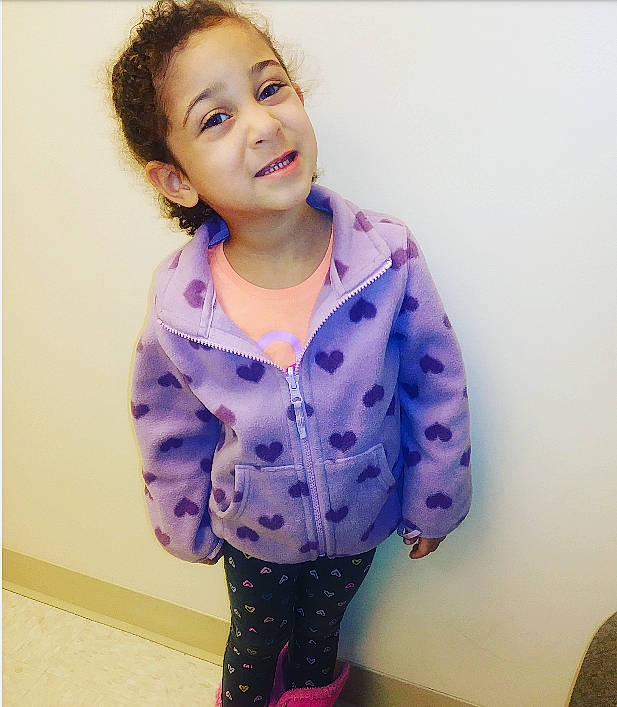 Jersie is registered to the contest to win money with this photo: blue, cheek, child, clothing, face, facial_expression, hair, hairstyle, head, lip, nose, outerwear, person, pink, purple, skin, sleeve, smile, standing, toddler