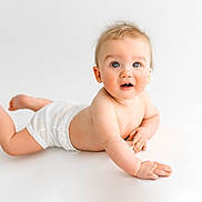 Tobias is registered to the contest to win money with this photo: baby, infant, diaper, blue_eyes, curious, tousled_hair, white_background, lying_down, child, cute, skin, bare_chest, small_hands, small_feet, portrait, studio_shot, expression, looking_up, minimalist, soft_lighting