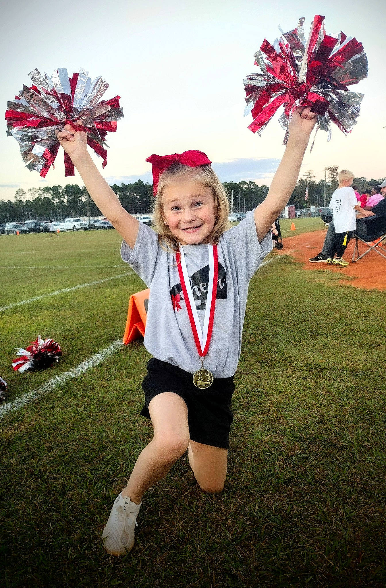 Karson Swearingen joined the competition — help win amazing prizes! cheerleading, cheerleading_uniform, competition_event, event, fun, gesture, grass, happy, joy, mammal, person, player, pom_pom, recreation, sky, smile, sports, team, team_sport, toddler
