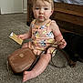 Daniella joined the competition — help win amazing prizes! toddler, child, carpet, purse, brown_purse, michael_kors, card, dog, bedroom, bed, wooden_bedframe, clothing, pink_outfit, sitting, floor, person, indoor, curious, cute, baby