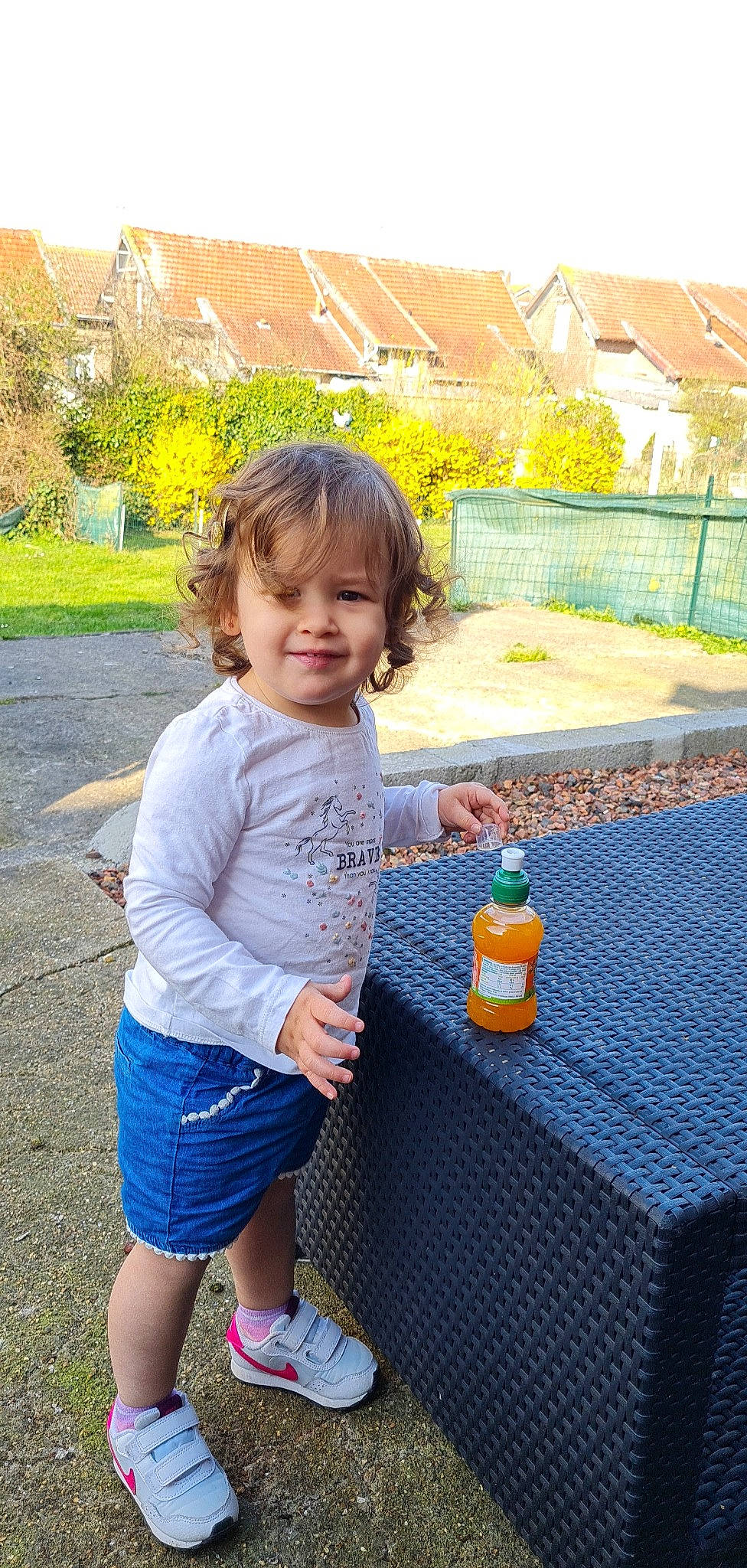 Mélissa participe au concours pour gagner de l'argent avec cette photo : baby_toddler_clothing, bottle, building, fun, grass, happy, house, joy, leaf, leisure, people_in_nature, person, plant, plastic_bottle, recreation, shorts, smile, toddler, tree, water_bottle