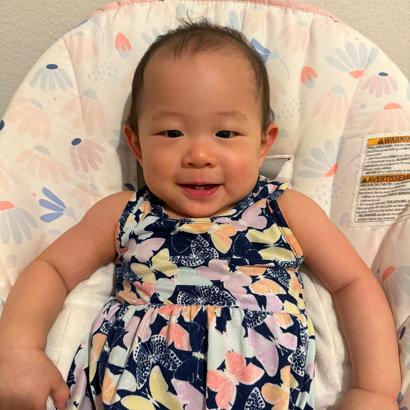 Hailyn is registered to the contest to win money with this photo: arm, baby, butterfly_pattern, child, cushion, cute, dress, eyes, face, hair, hand, happy, indoor, infant, person, photography, seat, skin, smiling, wall