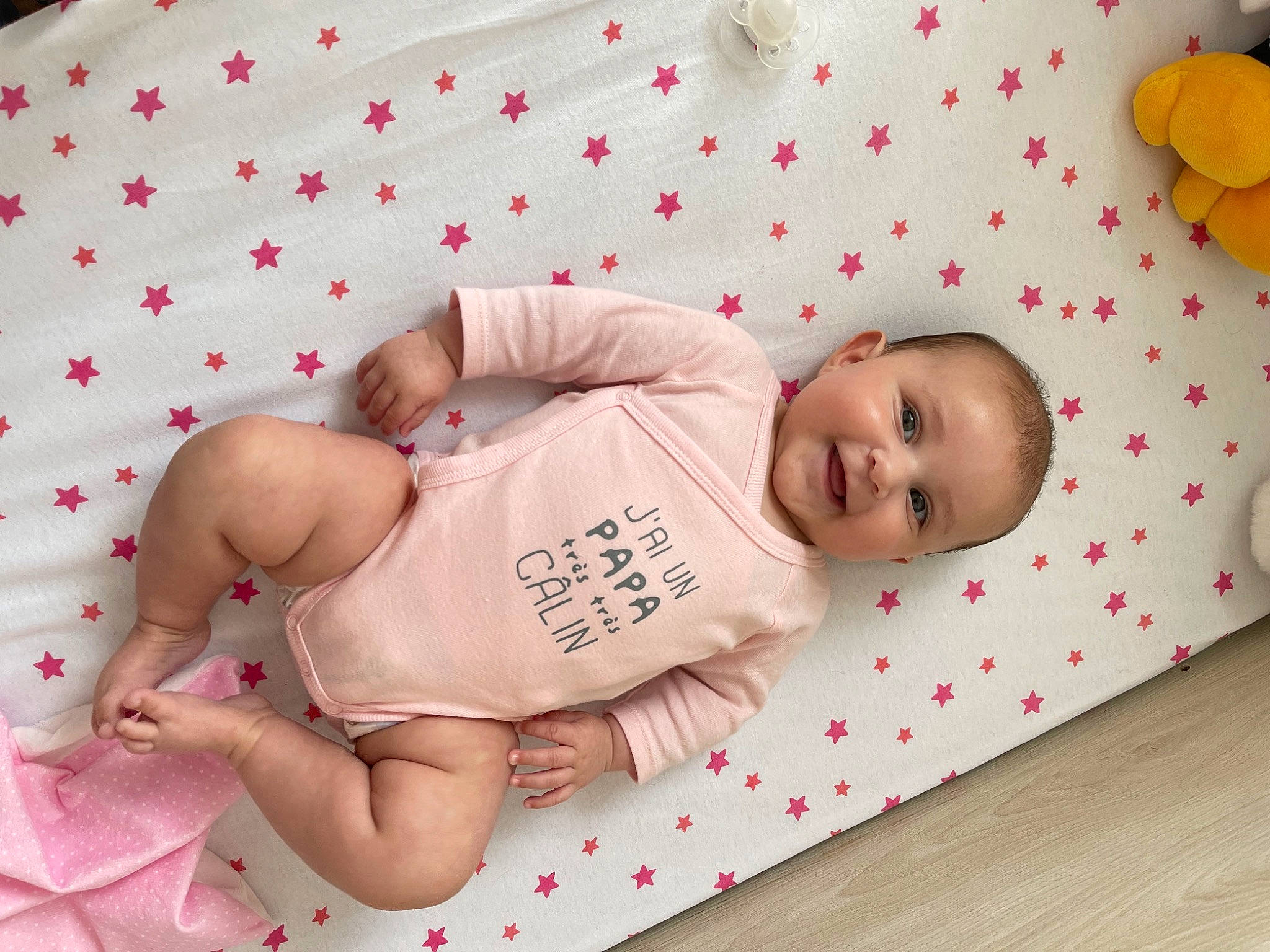 Lyna participe au concours pour gagner de l'argent avec cette photo : baby, baby_toddler_clothing, chest, child, comfort, face, facial_expression, finger, flooring, head, knee, pattern, person, pink, skin, sleeve, stomach, thigh, toddler, white