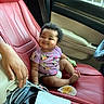 baby, child, car_interior, red_leather_seat, onesie, cartoon_characters, smiling, hand, seat, window, door, dashboard, steering_wheel, cable, technology, comfort, cute, infant, happy, portrait