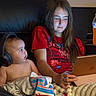 Asher is registered to the contest to win money with this photo: baby, child, sibling, girl, headphones, tablet, couch, blanket, indoor, portrait, sitting, electronics, red_shirt, spiderman_shirt, brown_hair, long_hair, infant, family, juice_bottle, cozy