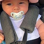 Léa participe au concours pour gagner de l'argent avec cette photo : adorable, baby, car_seat, child, closeup, cute, expression, face, hat, headwear, infant, minnie_mouse, pacifier, safety, seatbelt, sitting, soft_lighting, straps, white_clothing, young_child