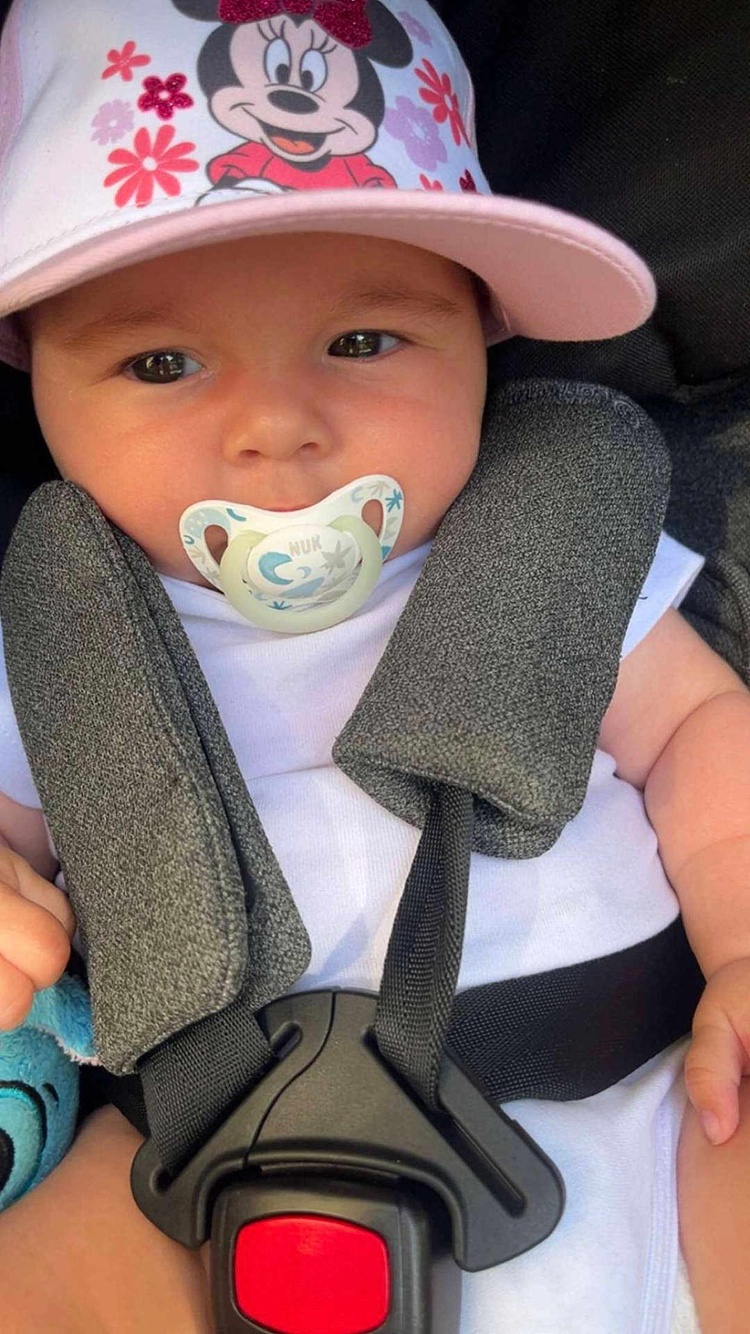 Léa participe au concours pour gagner de l'argent avec cette photo : adorable, baby, car_seat, child, closeup, cute, expression, face, hat, headwear, infant, minnie_mouse, pacifier, safety, seatbelt, sitting, soft_lighting, straps, white_clothing, young_child